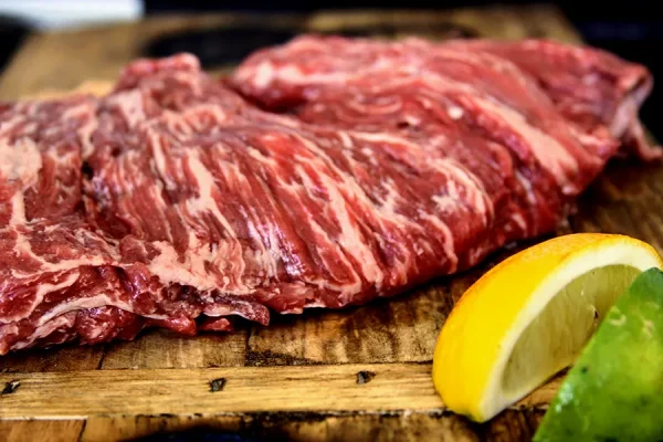 carne asada surrounded by garlic lemon lime on a Park Ranch branded JP cutting board