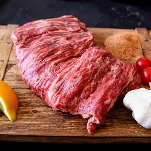 carne asada surrounded by garlic lemon lime on a Park Ranch branded JP cutting board