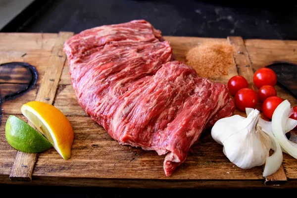 carne asada surrounded by garlic lemon lime on a Park Ranch branded JP cutting board