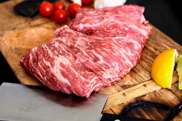 carne asada surrounded by garlic lemon lime on a Park Ranch branded JP cutting board