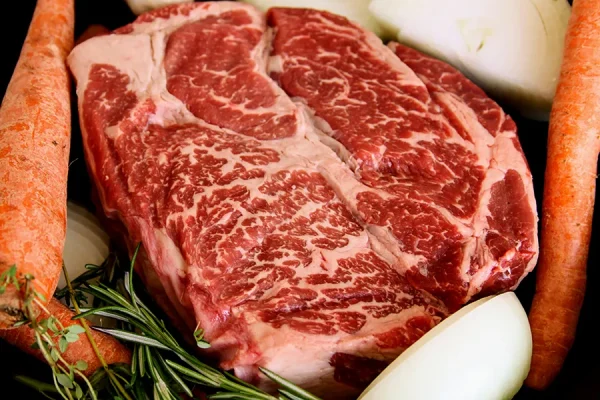 chuck roast surrounded by veggies in a cast iron pan