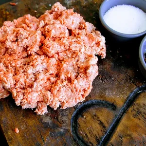 ground beef with peppercorns and salt on a Park Ranch branded JP cutting board