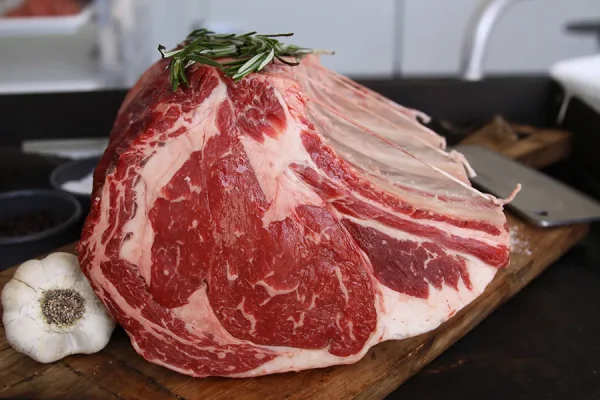 fresh bone-in prime rib on the cutting board ready for holiday celebrations